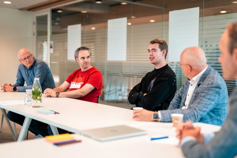 Richard Verschoor in gesprek met NetRom-collega’s tijdens een interview.