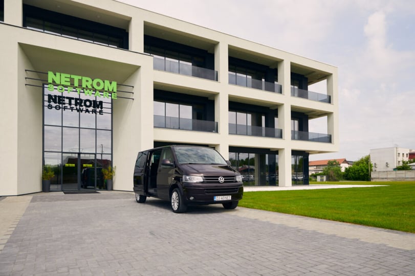 Exterior of the NetRom Campus in Craiova with a vehicle near the entrance.