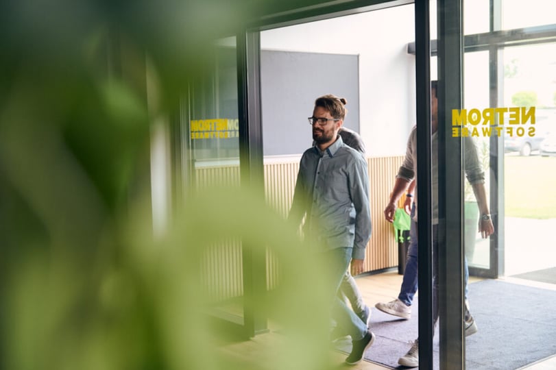 NetRom-ontwikkelaar loopt een kantoorruimte binnen.