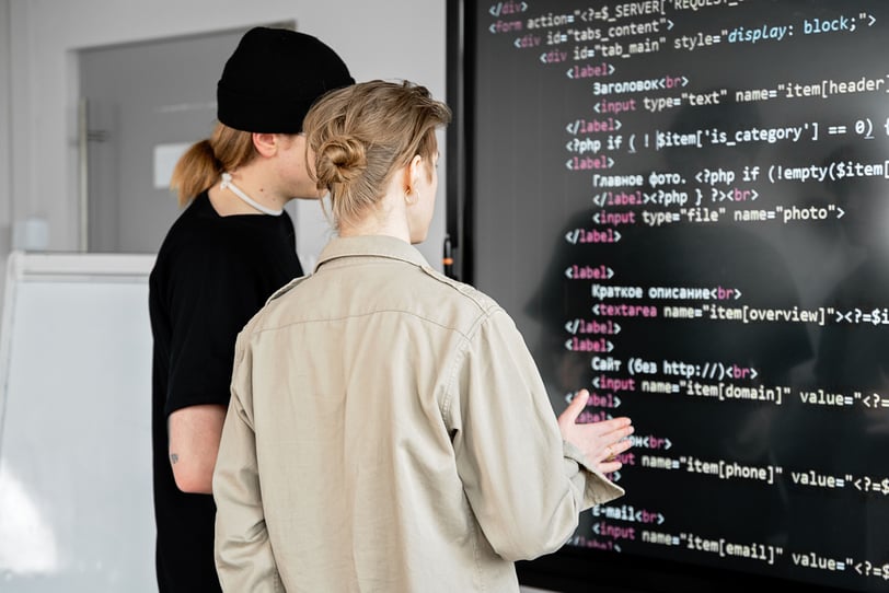 Software developers reviewing code during the technical implementation of a software solution