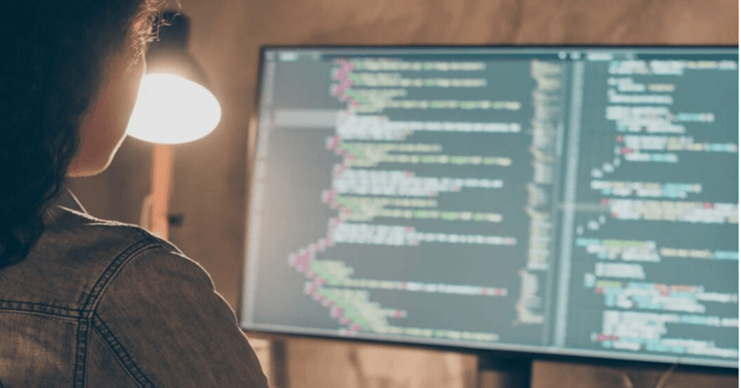 Softwareontwikkelaar werkt met code op een groot beeldscherm
