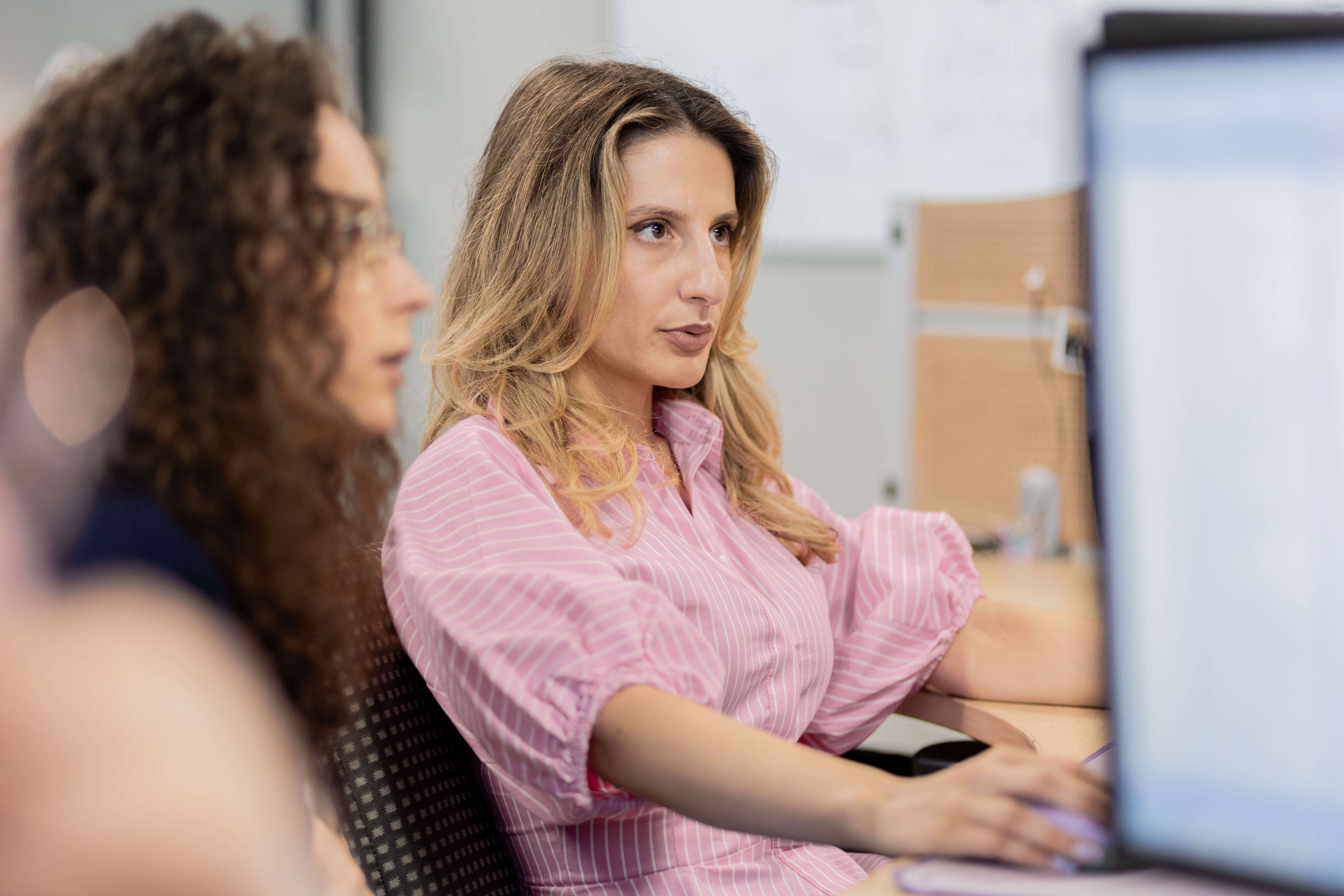 Vrouwelijke softwareontwikkelaars werken samen achter een computer