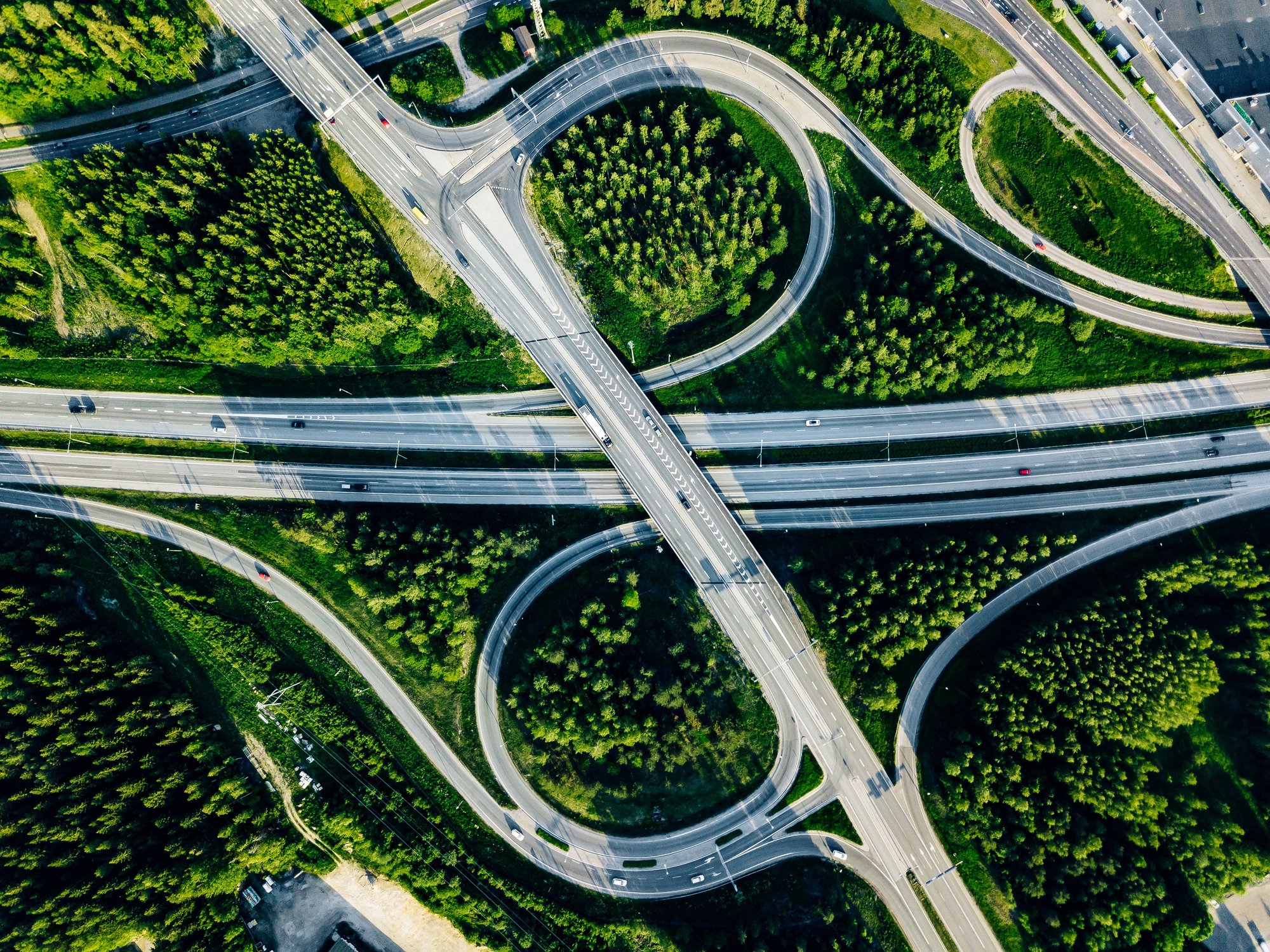 Aerial view of a highway interchange surrounded by greenery for transportation and fleet management