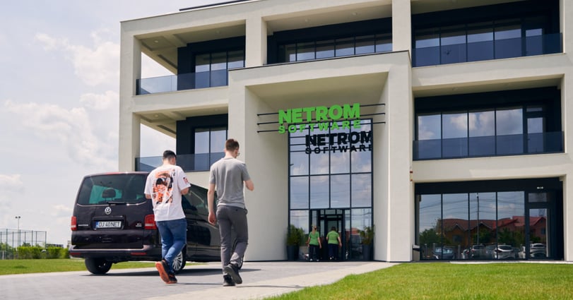 Buitenzijde van de NetRom Campus in Craiova met medewerkers bij de ingang.