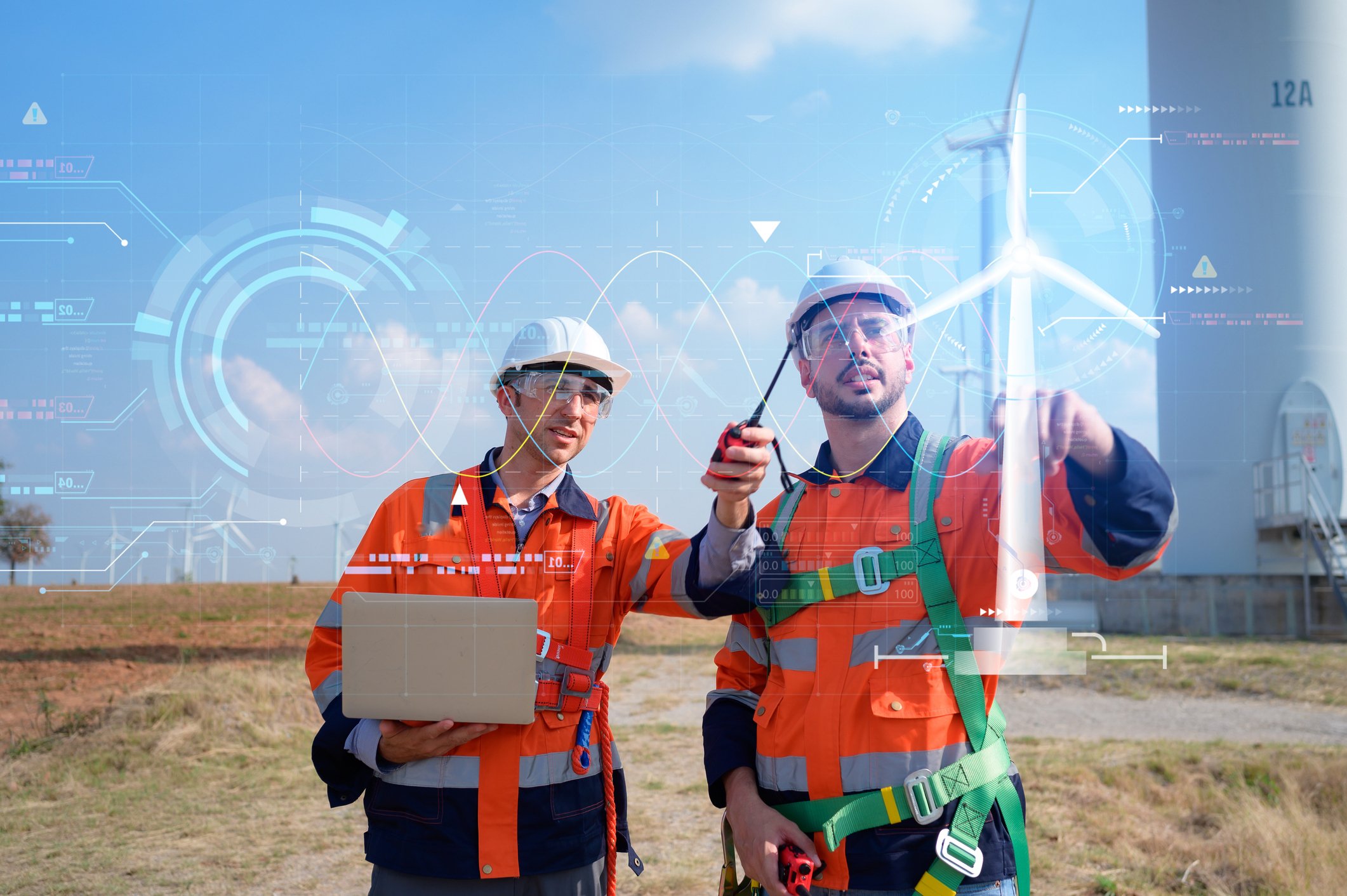 Field engineers inspecting wind turbines using digital monitoring technology