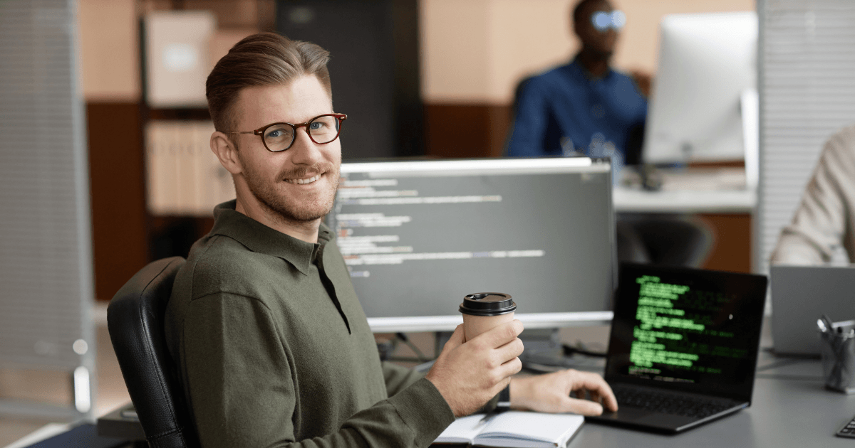 Software developer working behind multiple screens with code