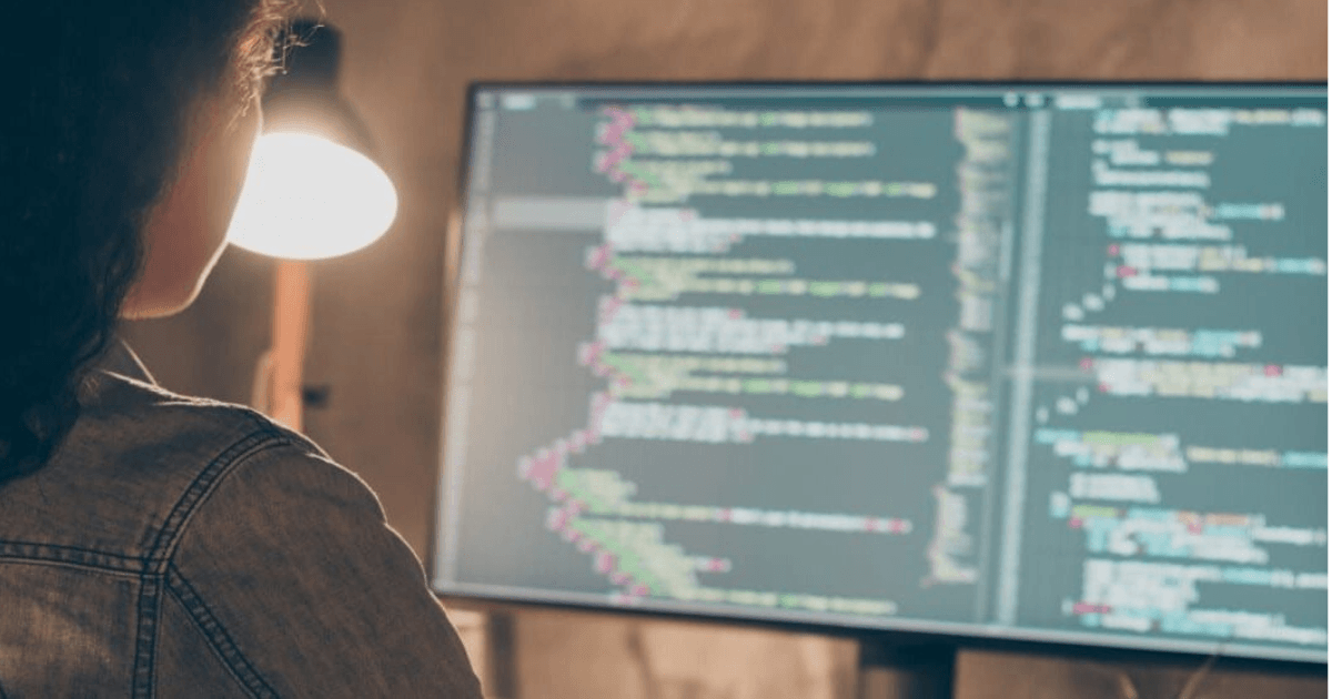 Softwareontwikkelaar werkt met code op een groot beeldscherm
