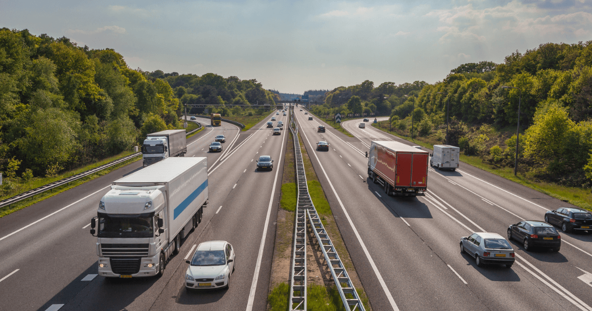 Luchtfoto van vrachtwagens en auto's op een Nederlandse snelweg, gebruikt als visualisatie van logistieke processen binnen het artikel over fleet management software ontwikkelen
