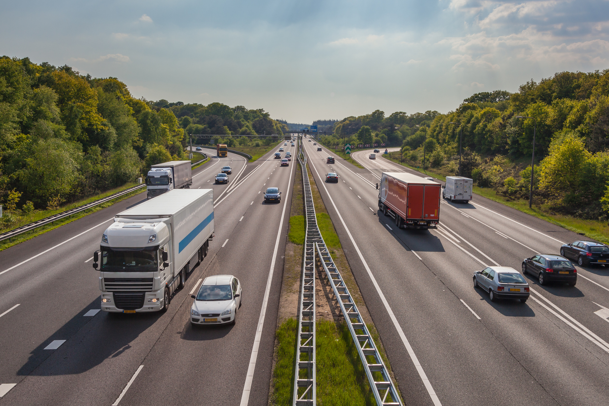 Vrachtwagens en auto's op een snelweg als beeld voor fleet management in transport en logistiek