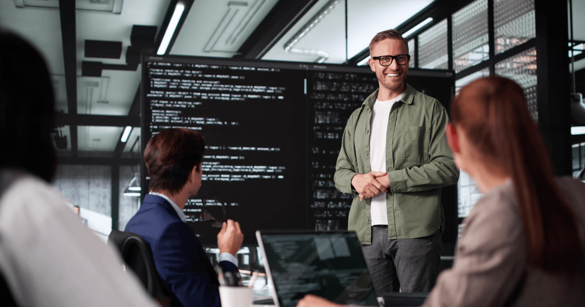 Softwareteam bespreekt code op een groot scherm tijdens een technische werksessie